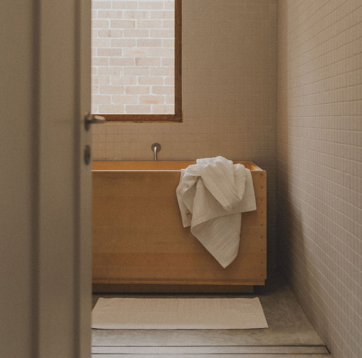 Bathroom with wooden bathtub and towel set